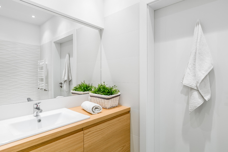Bright bathroom with structural tiles and wooden vanity cabinetの写真素材