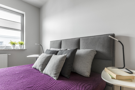 Cozy double bed with bedside tables in white bedroomの写真素材