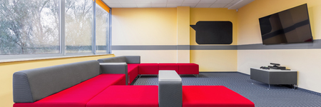 Panorama of modern university tv room for students to relax with extra large sofaの写真素材