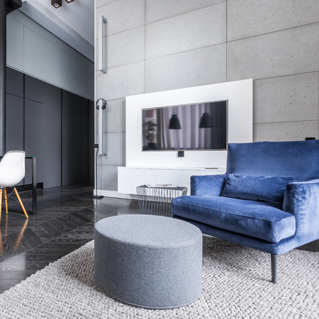 Living room with television, pouf table and armchairの写真素材