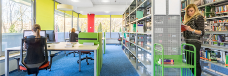 Panorama of colorful library interior with computer workstation and modern shelvingの写真素材