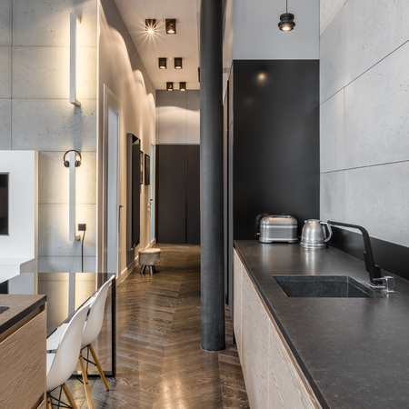 Kitchen with black countertop, black table and white chairsの写真素材