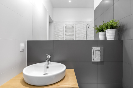 Contemporary bathroom interior with white round washbasin and big white and grey tilesの写真素材