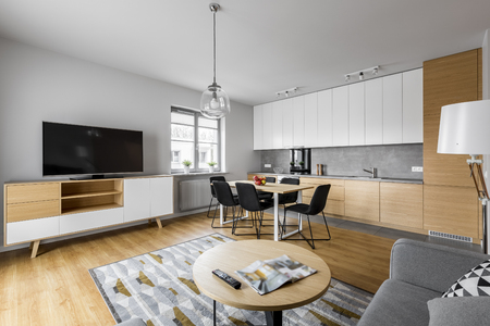 Modern open space kitchen with living room and big televisionの写真素材