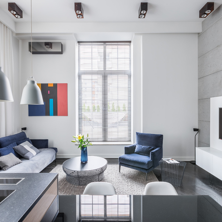 Stylish living room with big window and blue upholstered furnitureの写真素材
