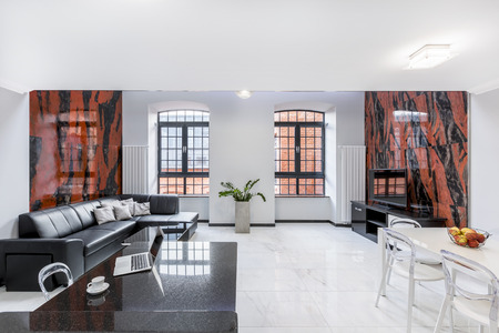 Luxury, white loft apartment with sofa, table, window, gloss floor and design wall tilesの写真素材