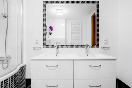 White, modern villa bathroom with basin cabinet, mirror and bathtubの写真素材
