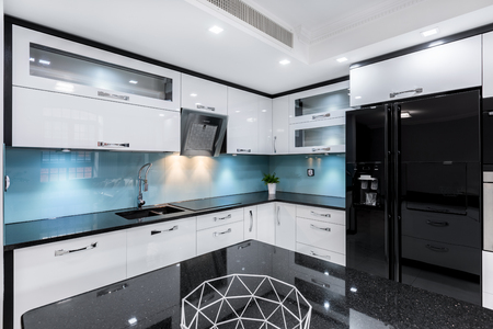 Modern, black and white gloss kitchen with table and countertopの写真素材