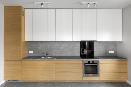 Grey kitchen with wooden cabinets, granite worktop and white cupboardsの写真素材