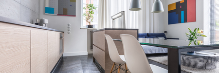 Contemporary kitchen with table, white chairs and wooden cupboard, panoramaの写真素材