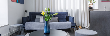 Flowers in vase on coffee table in stylish living room, panoramaの写真素材