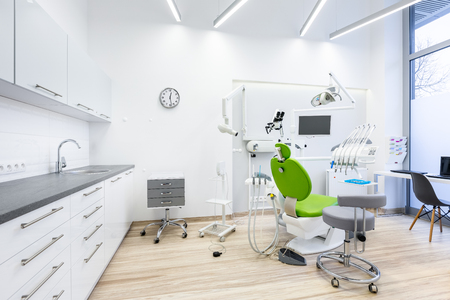 Clinic interior with modern dental unit, white furniture and grey worktopの写真素材