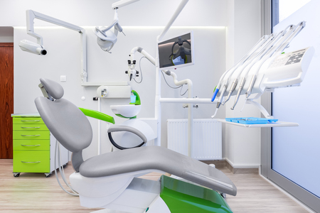 White dental office with grey chair, modern microscope and led lampの写真素材