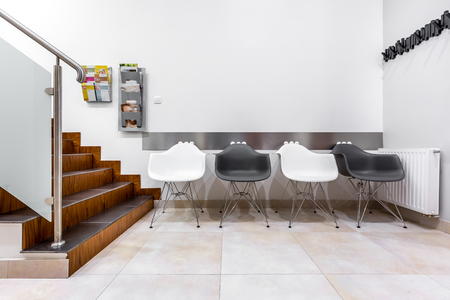 Modern waiting room with stairs, black and white chairs and glass balustradeの写真素材