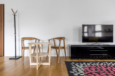Wooden chairs and table in leisure room with tv screenの写真素材