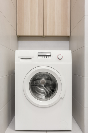 Space for washing machine and wooden cabinet in bathroomの写真素材