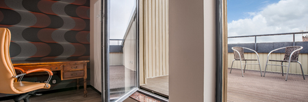 Private home office interior with big windows and exit to the modern balcony, panoramaの写真素材