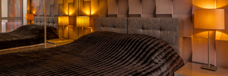 Modern designed bedroom with creative brown 3D wallpaper and big bed, panoramaの写真素材