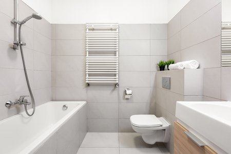 Light beige bathroom with bathtub and countertop basinの写真素材