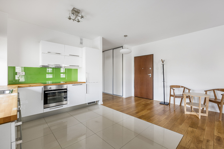 Kitchen with modern, white furniture and beige floor tilesの写真素材