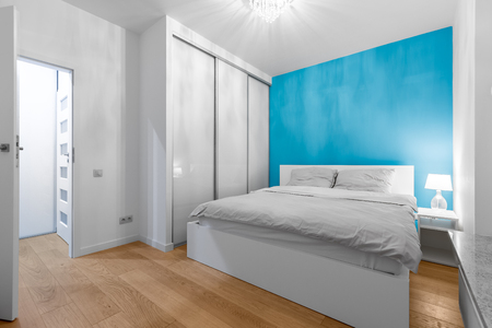 Modern bedroom with double bed, closet and blue wallの写真素材