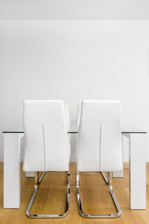 Modern apartment with glass table and white chairsの写真素材