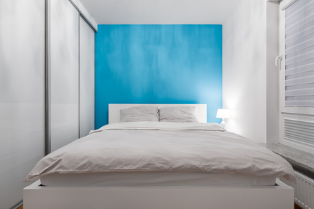 White bedroom with azure wall,closet and double bedの写真素材