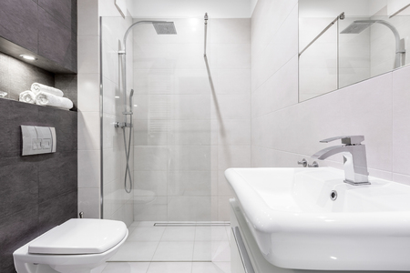 Gray and white bathroom with shower, basin and toiletの写真素材