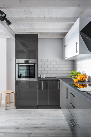 Elegant kitchen interior with brick wall, gray furniture and wooden floorの写真素材