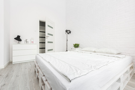 Loft bedroom with white brick wall and pallet bedの写真素材
