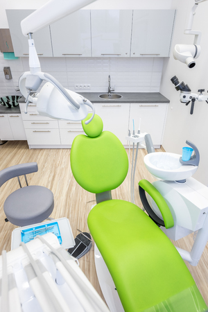 Bright treatment room with modern, green dental chairの写真素材
