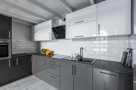 Modern kitchen with white brick tiles and wooden ceilingの写真素材