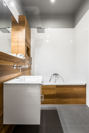 Modern and elegant bathroom with mirror, bathtub and cabinetの写真素材