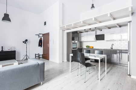 Open plan apartment with kitchenette dining table and living roomの写真素材