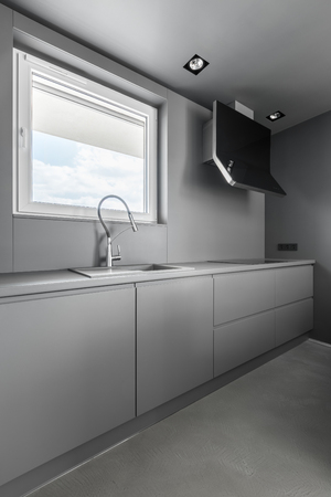 Gray kitchen with modern cupboards and window with blindsの写真素材