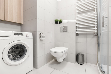 Modern, gray bathroom with washer, shower and toiletの写真素材