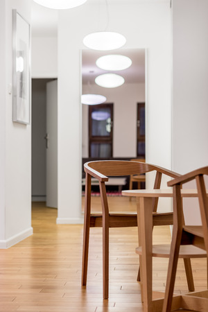 White, home interior with modern lamps, wooden chairs and small tableの写真素材