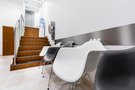Clinic interior with white and black chairs in waiting roomの写真素材