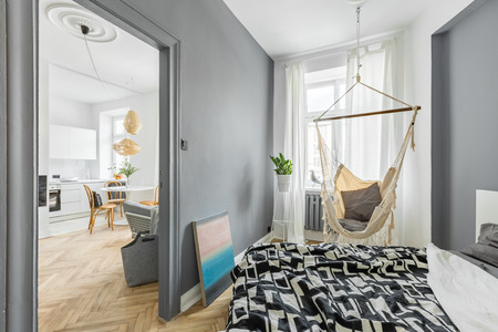 Gray bedroom with double bed, hammock and modern artの写真素材