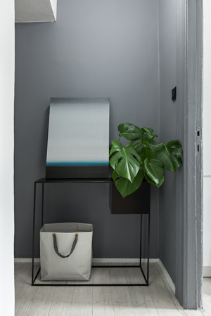 Gray interior with black, metal table, modern painting and plantの写真素材