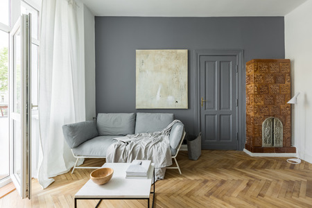 Gray and white living room with vintage tiled stoveの写真素材
