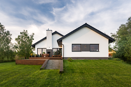 Stylish, white house with garden and terrace, exterior view