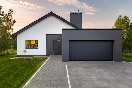 Modern house with garage and green lawn, exterior viewの写真素材