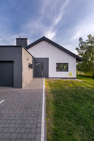 Modern house with cobblestone driveway and garage, exterior viewの写真素材