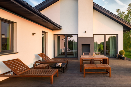 Exterior view of house with patio with wooden furnitureの写真素材
