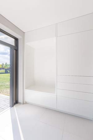 White, home interior with modern wardrobe and open doorの写真素材