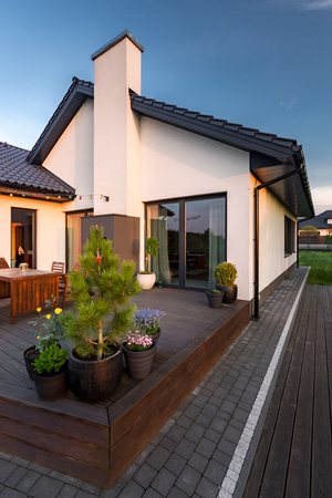 Exterior view of cozy family house with patio and decorative plantsの写真素材
