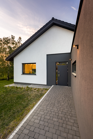 White, simple family house with cobblestone entry pathwayの写真素材
