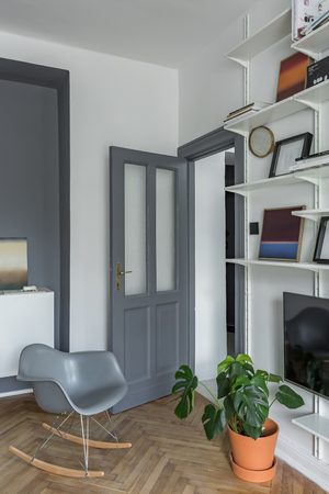 Apartment with gray decorations, wooden floor and white bookcaseの写真素材