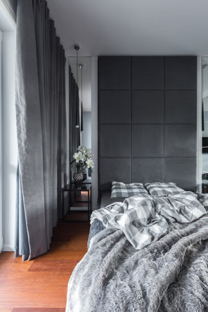 Gray bedroom with double bed, upholstered wall and curtains